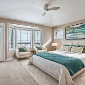 Bright bedroom with large windows, a landscape painting, and a cozy ambiance. Features a king-size bed, teal accents, and plush chairs, evoking tranquility.